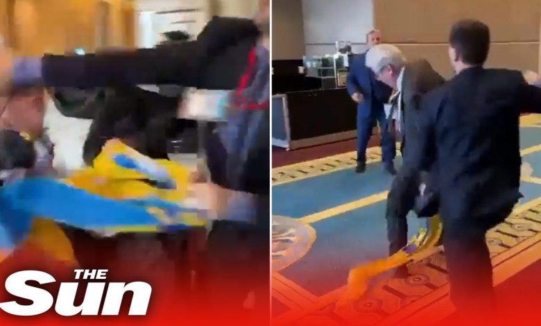 Es kommt zu einem Faustkampf, als ein russischer Diplomat auf einer Konferenz die ukrainische Flagge herunterreißt Es kommt zu einem Faustkampf, als ein russischer Diplomat auf einer Konferenz die ukrainische Flagge herunterreißt