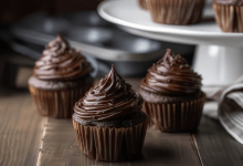 A plate of beautifully decorated chocolate cupcakes with chocolate frosting and sprinkles. A plate of beautifully decorated chocolate cupcakes with chocolate frosting and sprinkles.