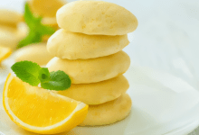 Vegan lemon sandwich cookies arranged on a plate with fresh mint leaves. Vegan lemon sandwich cookies arranged on a plate with fresh mint leaves.