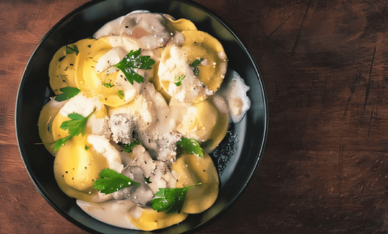 A plate of creamy ravioli garnished with fresh herbs and parmesan cheese. A plate of creamy ravioli garnished with fresh herbs and parmesan cheese.