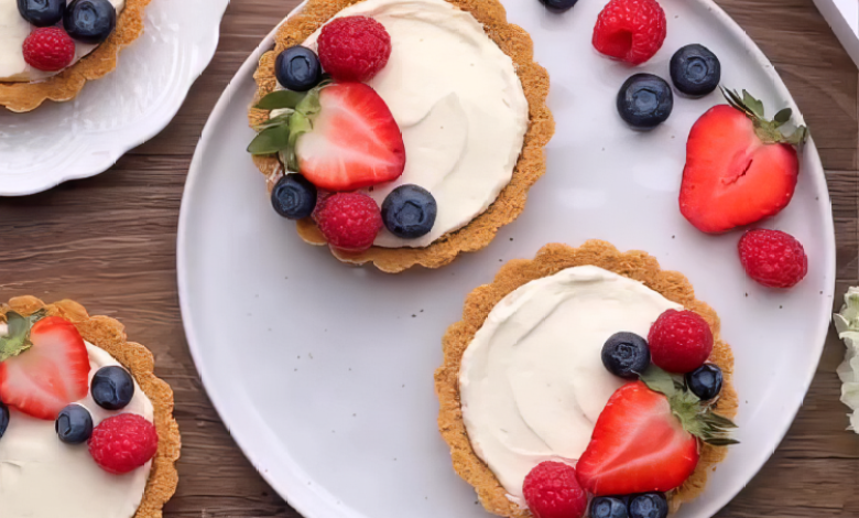 A tray of mini cheesecakes with white chocolate fillings, topped with fresh berries. A tray of mini cheesecakes with white chocolate fillings, topped with fresh berries.