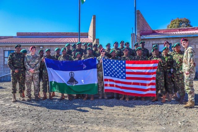 U.S. Military and Lesotho Defense Force stand united, proudly displaying Lesotho and American flags, symbolizing collaboration and shared commitment to a brighter future. U.S. Military and Lesotho Defense Force stand united, proudly displaying Lesotho and American flags, symbolizing collaboration and shared commitment to a brighter future.