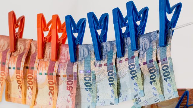 South African currency hangs on a washing line, symbolizing the ongoing battle against money laundering under FATF scrutiny. South African currency hangs on a washing line, symbolizing the ongoing battle against money laundering under FATF scrutiny.