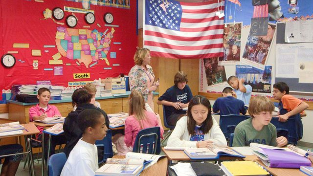 A vibrant American classroom thrives under the Stars and Stripes, where students and their teacher engage in learning. A vibrant American classroom thrives under the Stars and Stripes, where students and their teacher engage in learning.