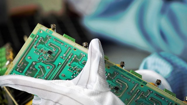 A technician handles a PCB with semiconductors, symbolizing the sensitive technology Cadence Design Systems illegally exported to China’s military university. A technician handles a PCB with semiconductors, symbolizing the sensitive technology Cadence Design Systems illegally exported to China’s military university.