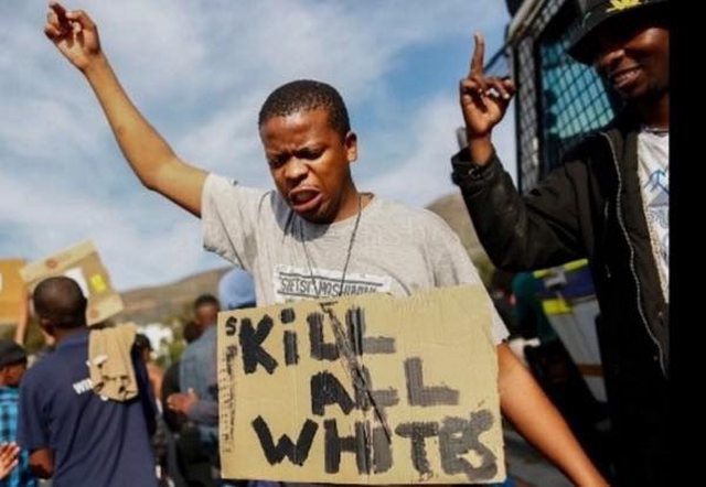 Protestor with sign calling to "KILL ALL WHITES." Protestor with sign calling to "KILL ALL WHITES."