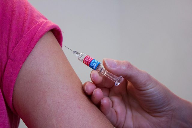 A doctor preparing to administer a vaccine. A doctor preparing to administer a vaccine.