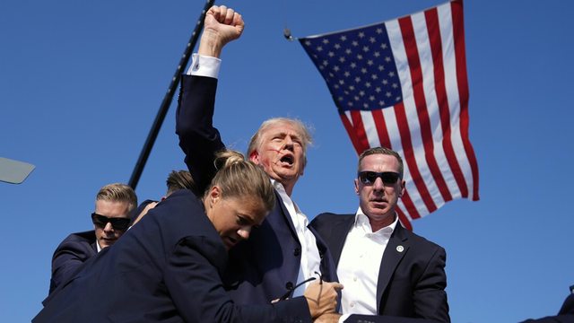 Defiance in the Face of Danger: President Trump raises his fist, blood-streaked, moments after the July 13, 2024 assassination attempt in Butler, Pennsylvania, surrounded by U.S. Secret Service agents. Defiance in the Face of Danger: President Trump raises his fist, blood-streaked, moments after the July 13, 2024 assassination attempt in Butler, Pennsylvania, surrounded by U.S. Secret Service agents.