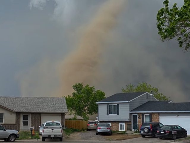 A tornado in the background of homes in Colorado. A tornado in the background of homes in Colorado.