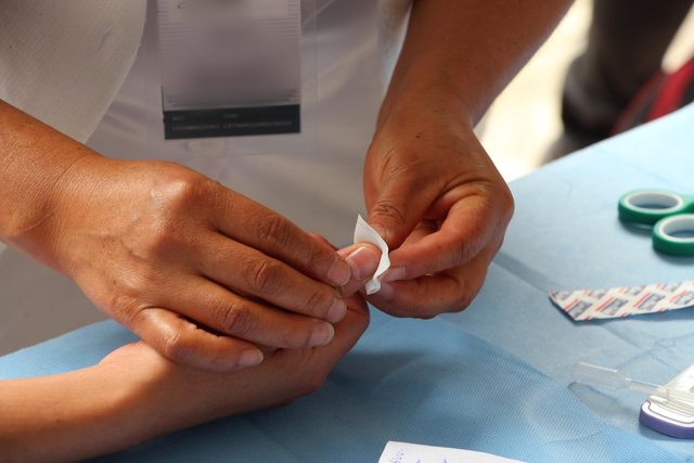 A nurse treating a patient. A nurse treating a patient.