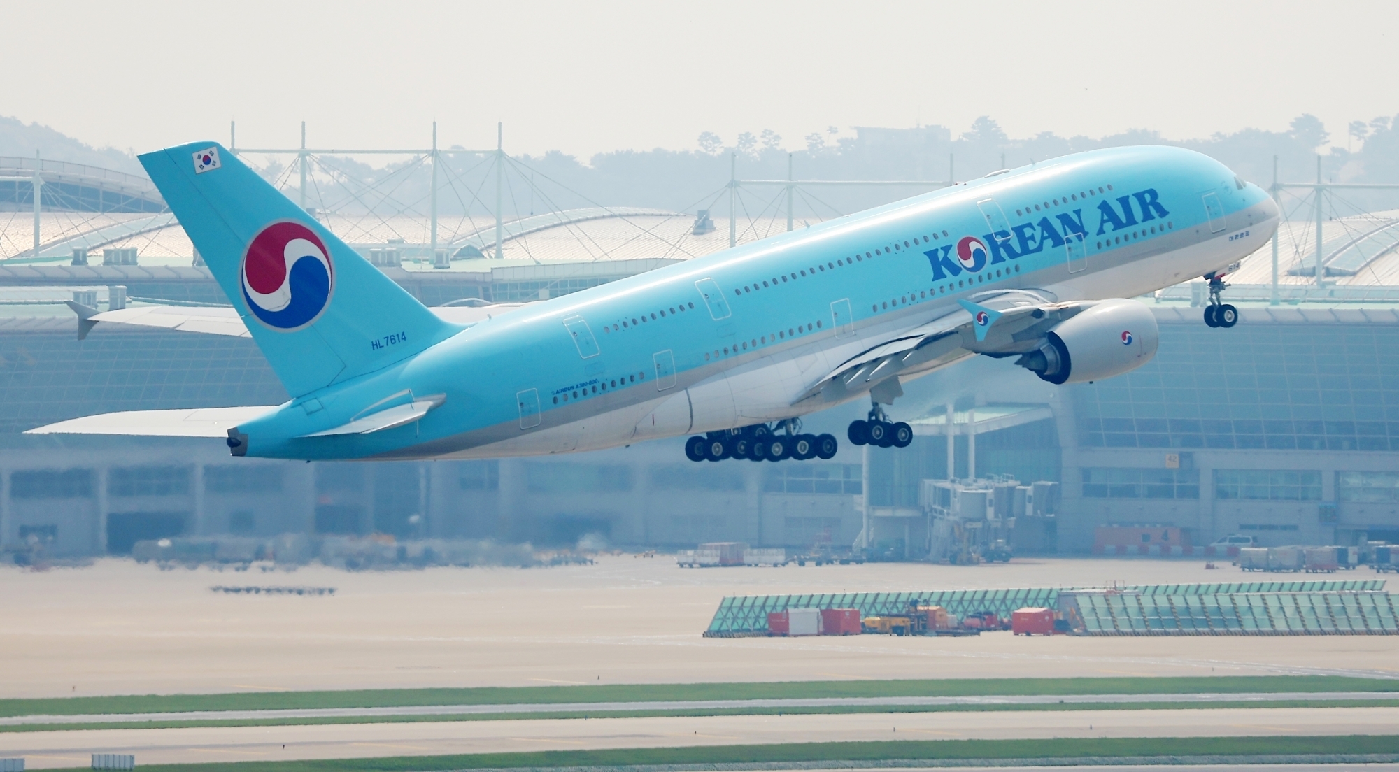 Korean Air plane at airport with fuel surcharge announcement graphic Korean Air plane at airport with fuel surcharge announcement graphic