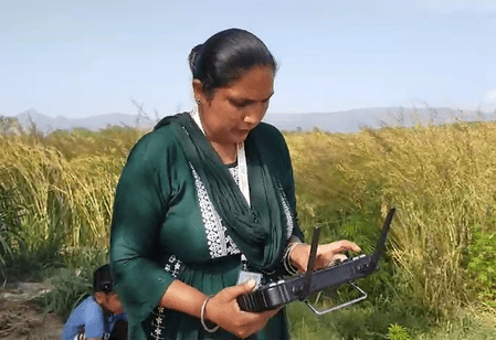 Drone Didi Gurdeep Kaur operating agricultural drone in Punjab field Drone Didi Gurdeep Kaur operating agricultural drone in Punjab field