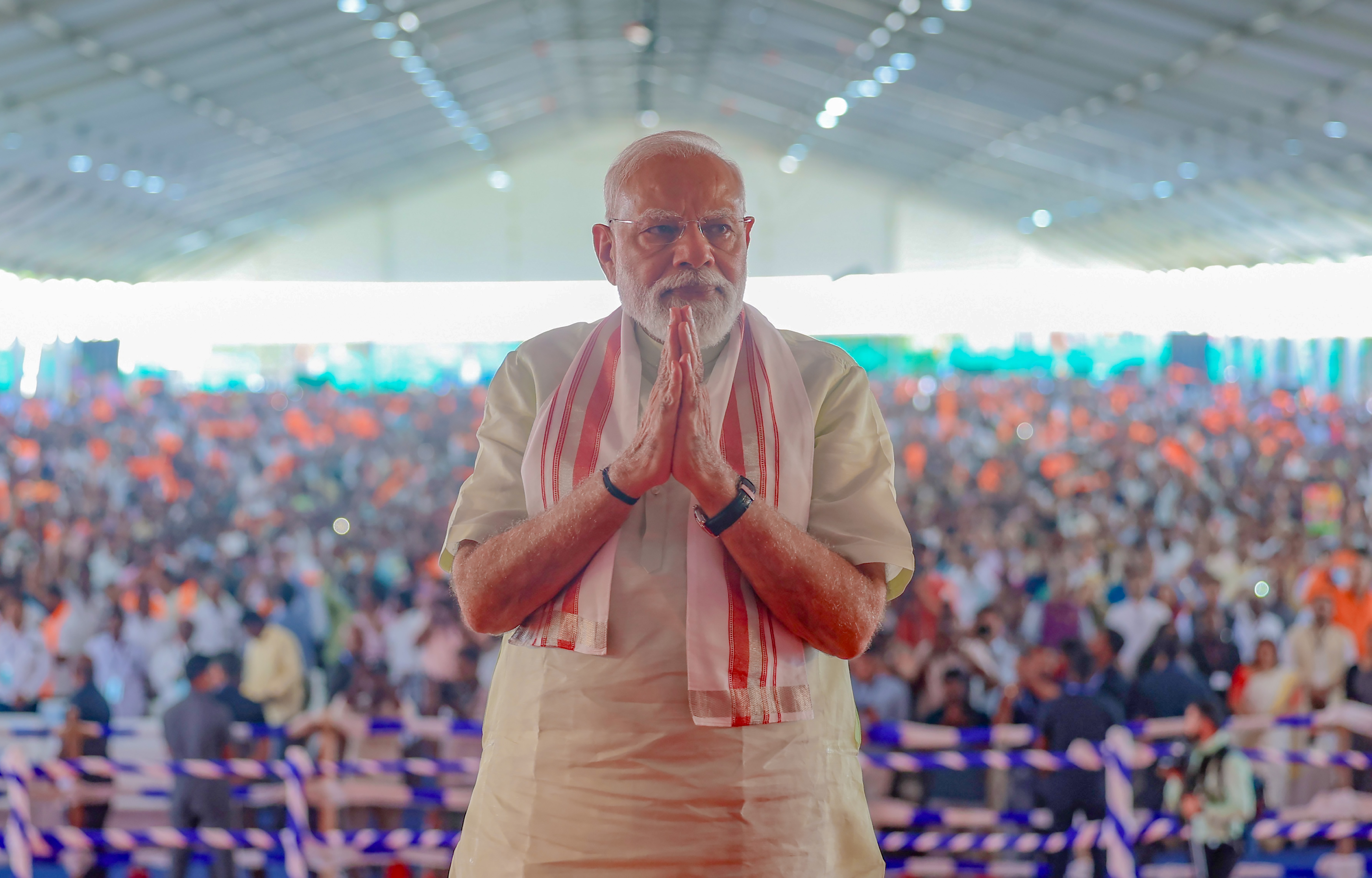 PM Modi speaking at an event with YouTube subscriber milestone graphics PM Modi speaking at an event with YouTube subscriber milestone graphics