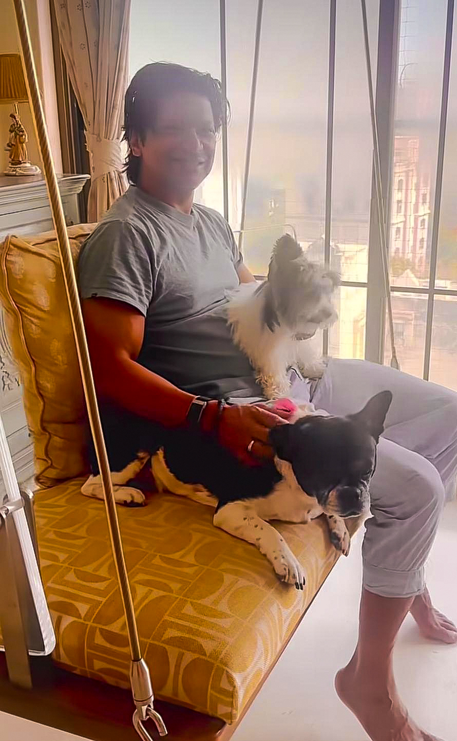 Shaan relaxing at home with his pet dogs on a swing, showcasing his dopamine Shaan relaxing at home with his pet dogs on a swing, showcasing his dopamine