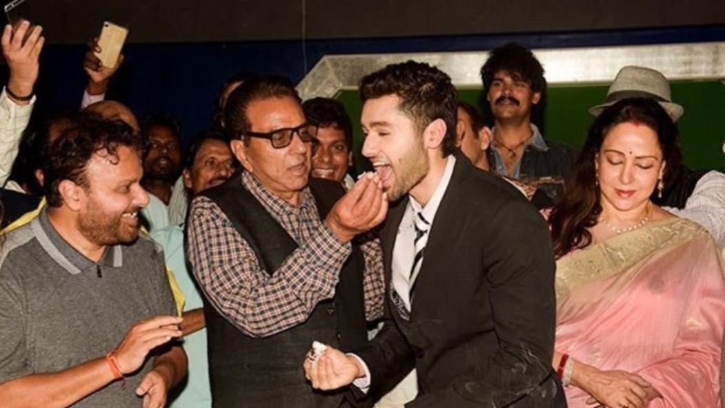 Dharmendra feeding cake to Utkarsh Sharma on his birthday while Hema Malini and Anil Sharma watch Dharmendra feeding cake to Utkarsh Sharma on his birthday while Hema Malini and Anil Sharma watch