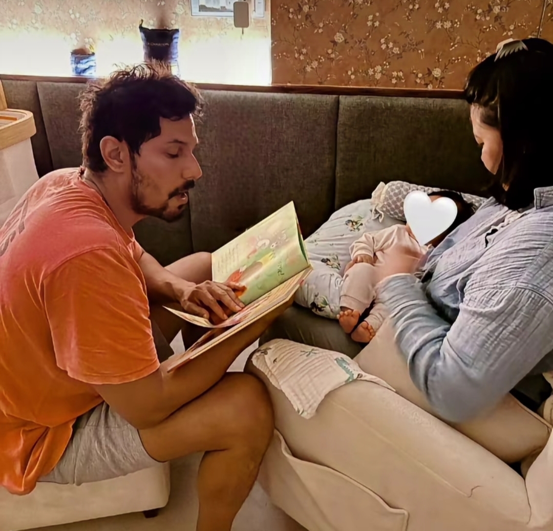 Randeep Hooda reading a book to baby Nyomica with wife Lin Laishram Randeep Hooda reading a book to baby Nyomica with wife Lin Laishram