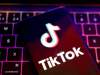 Más de la mitad de los videos más populares de TikTok sobre salud mental contienen información errónea Teléfono móvil con la pantalla encendida mostrando el logotipo de TikTok, apoyado sobre un teclado retroiluminado de un ordenador portátil con luces de colores púrpura y rosa.