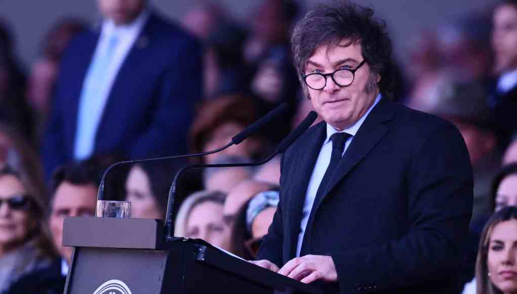 El presidente de Argentina, Javier Milei, hablando en un podio durante un evento, vestido con traje oscuro y corbata, y usando gafas. Detrás de él, se ven varias personas en el público desenfocadas. El presidente de Argentina, Javier Milei, hablando en un podio durante un evento, vestido con traje oscuro y corbata, y usando gafas. Detrás de él, se ven varias personas en el público desenfocadas.