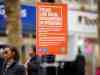 Sistema de reconocimiento facial Facewatch genera falsas identificaciones en tiendas del Reino Unido Cartel naranja colocado en una farola que informa sobre el uso de reconocimiento facial en tiempo real por parte de la policía. El texto indica “Police Live Facial Recognition in Operation”, y en el fondo se aprecia una calle con peatones desenfocados.