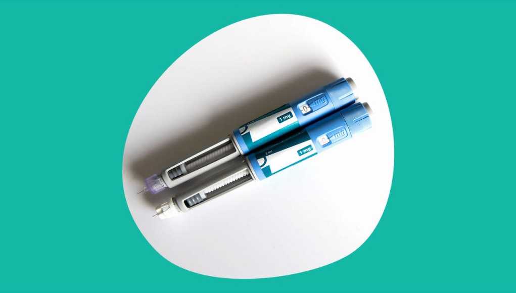 Fotografía de dos plumas inyectables de medicamento sobre un fondo blanco con borde irregular, enmarcado por un fondo verde. Los dispositivos son de color azul con etiquetas que indican una dosis de 1 mg y están equipados con agujas, lo que sugiere su uso médico, posiblemente para el tratamiento de diabetes u obesidad. Fotografía de dos plumas inyectables de medicamento sobre un fondo blanco con borde irregular, enmarcado por un fondo verde. Los dispositivos son de color azul con etiquetas que indican una dosis de 1 mg y están equipados con agujas, lo que sugiere su uso médico, posiblemente para el tratamiento de diabetes u obesidad.