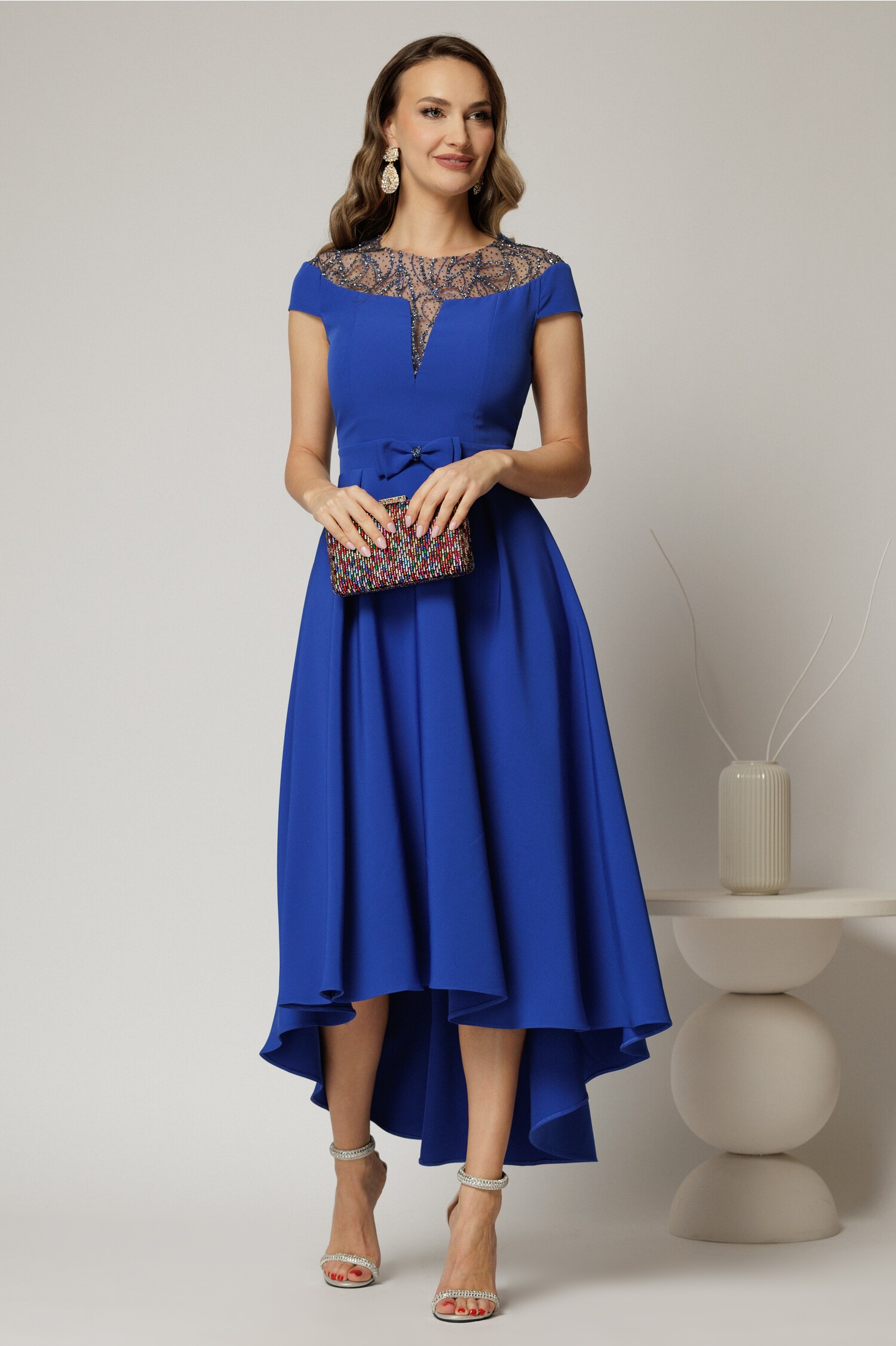 Rochie asimetrică albastră DY fashion cu funda în talie și aplicații la decolteu Rochie asimetrică albastră DY fashion cu funda în talie și aplicații la decolteu