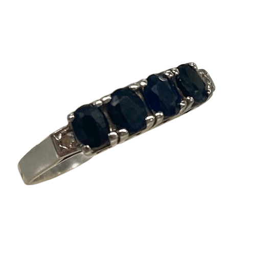 Ladies 9ct White Gold 6 Stone Sapphire & Diamond Ring. 4 Oval Sapphires, 4 Claw Set. With 2 Square Grain Set Diamonds In Swept Up Shoulders. TDW 1.15ct. Size P/8 . With Valuation Certificate – (NG 73254)