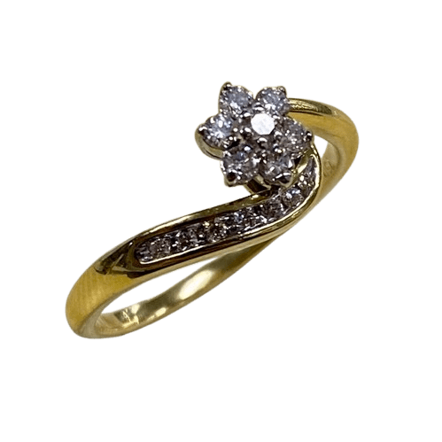 Ladies 18ct White & Yellow Gold 14 Stone Diamond Ring. Round Brilliant Cut White Gold 6 Claw Set Centre Stone Surrounded By 6 Round Brilliant Cut White Gold Claw Set Forming A Cluster. With 7 Brilliant Cut Diamonds Channel Set In Wrap Around Shoulder. TDW 0.26ct. Size R/9, With Valuation Certificate – (NG 147229)