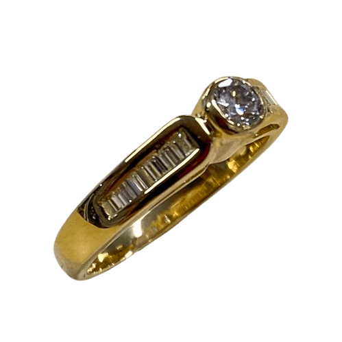 Ladies 18ct Gold 16 Stone Diamond Ring. Single Round Brilliant Cut Rub Over Set, 15 Baguette Cut Diamonds Channel Set In Swept Up Shoulders. TDW 0.50ct. Size K/5.5, With Valuation Certificate – (NG 104625)