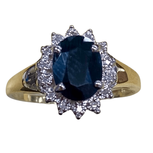 Ladies 9ct Yellow Gold 15 Stone Diamond & Sapphire Ring. Oval Sapphire In Rhodium 4 Claw Setting, Surrounded by 14 Single Cut Diamonds Illusion Bead Set in Rhodium Plated Basket, In Swept Up Shoulders. TDW 0.07ct. Size M/6.5, With Valuation Certificate – (NG 1307520)