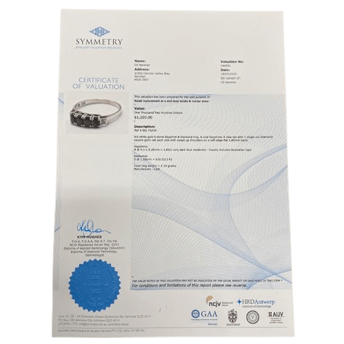 Ladies 9ct White Gold 6 Stone Sapphire & Diamond Ring. 4 Oval Sapphires, 4 Claw Set. With 2 Square Grain Set Diamonds In Swept Up Shoulders. TDW 1.15ct. Size P/8 . With Valuation Certificate – (NG 73254)