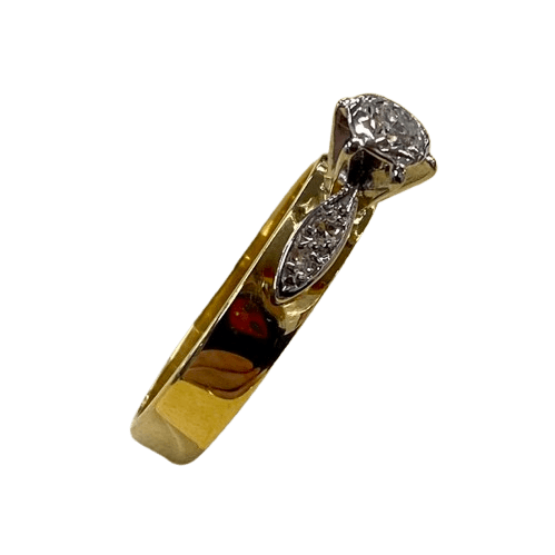 Ladies 18ct Yellow &White Gold 5 Stone Diamond Ring. Round Brilliant Cut Diamond White Gold Illusion Grain Set With Tapered 6 Claw Collet, With 4 Single Cut Diamonds Grain Set in White Gold Leaf Shoulders On Flat Band. TDW 0.24ct. Size M/6.5, With Valuation Certificate (NG 99547)