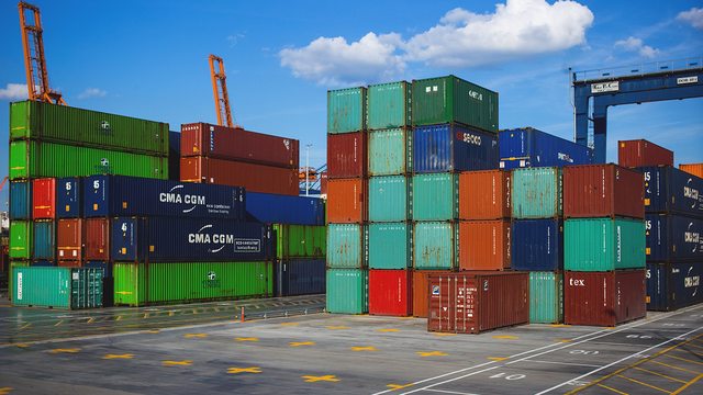 Colorful shipping containers stack high at a bustling port, ready for global trade. Colorful shipping containers stack high at a bustling port, ready for global trade.
