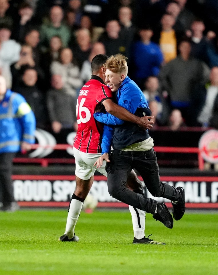 Pitch invader stopped from confronting Leicester boss as player tackles fan Pitch invader stopped from confronting Leicester boss as player tackles fan