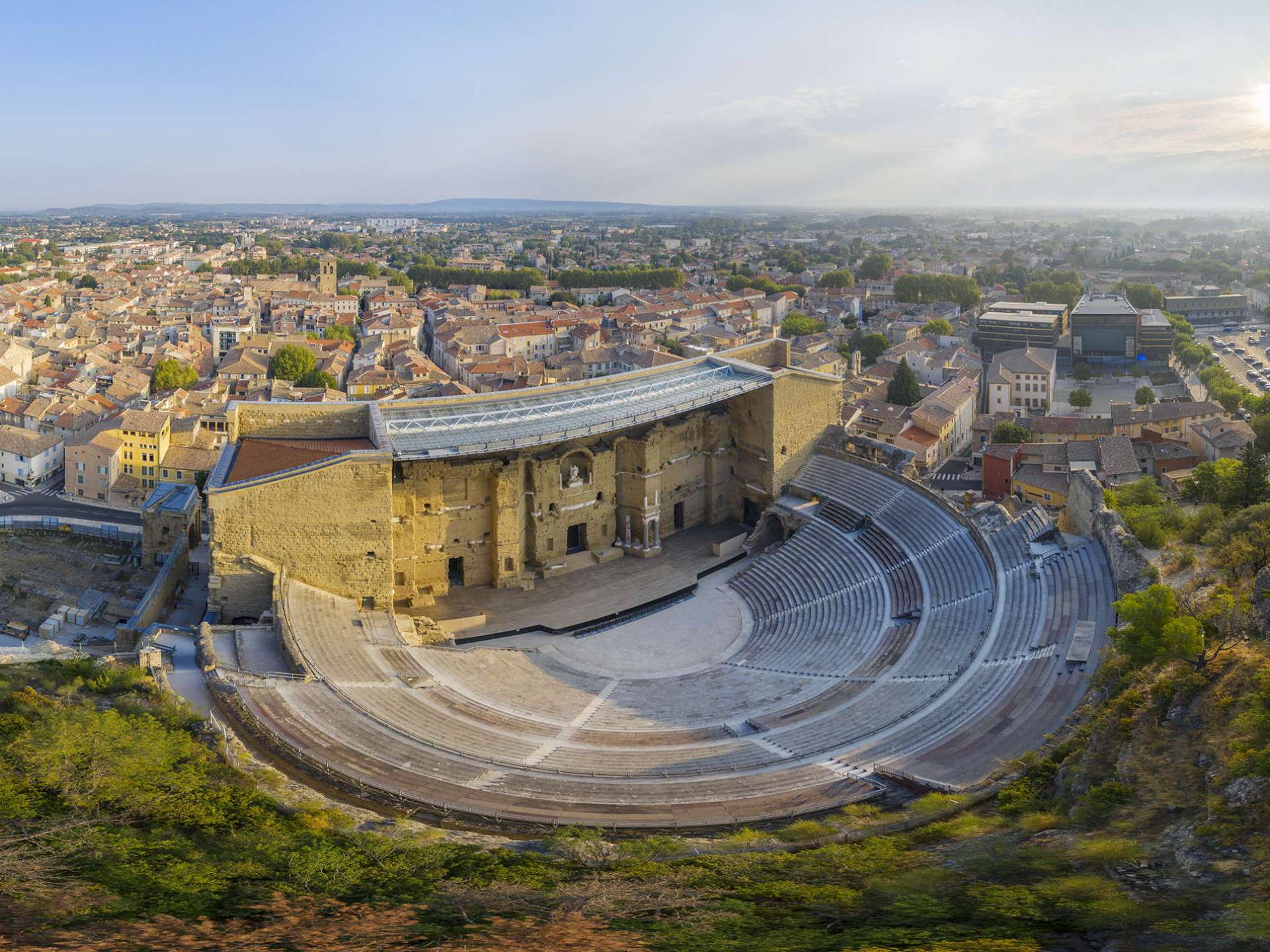 A vibrant view of the Orange Amphitheatre in Orange, showcasing its unique architecture and surrounding landscape. A vibrant view of the Orange Amphitheatre in Orange, showcasing its unique architecture and surrounding landscape.
