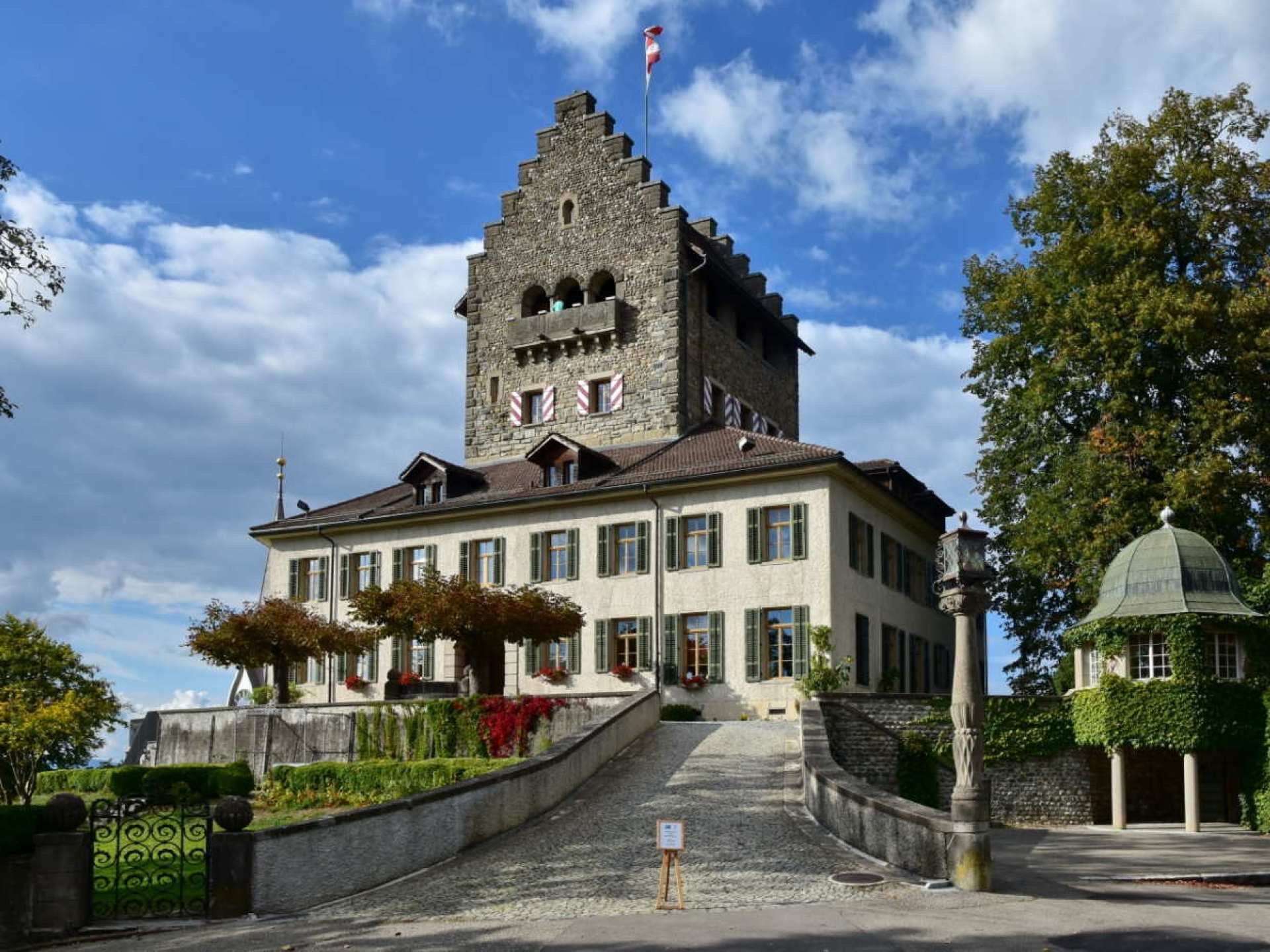 An aerial view of Uster Castle surrounded by lush greenery, showcasing its historical architecture in the heart of Uster, Switzerland. An aerial view of Uster Castle surrounded by lush greenery, showcasing its historical architecture in the heart of Uster, Switzerland.