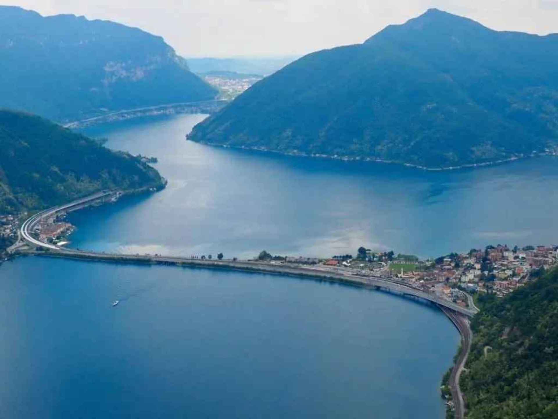 Scenic view of Lake Lugano surrounded by mountains in Lugano, showcasing the natural beauty of this Swiss city. Scenic view of Lake Lugano surrounded by mountains in Lugano, showcasing the natural beauty of this Swiss city.