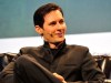Telegram proporcionará ahora direcciones IP y números de teléfono en respuesta a solicitudes legales La imagen muestra a Pavel Durov, el CEO de Telegram, sentado en un sillón durante una conferencia o entrevista. Viste un traje oscuro y lleva un micrófono de diadema en la oreja izquierda. Durov está sonriendo ligeramente mientras mira hacia un lado, proyectando una expresión relajada y confiada. El fondo de la imagen es borroso, lo que hace que el enfoque principal sea él mismo.