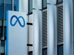 Meta discutió la compra de Perplexity antes de invertir en Scale AI Primer plano de un cartel con el logotipo de Meta (símbolo de infinito estilizado en azul) frente a la fachada moderna de un edificio de oficinas, con paneles metálicos verticales y ventanas acristaladas.