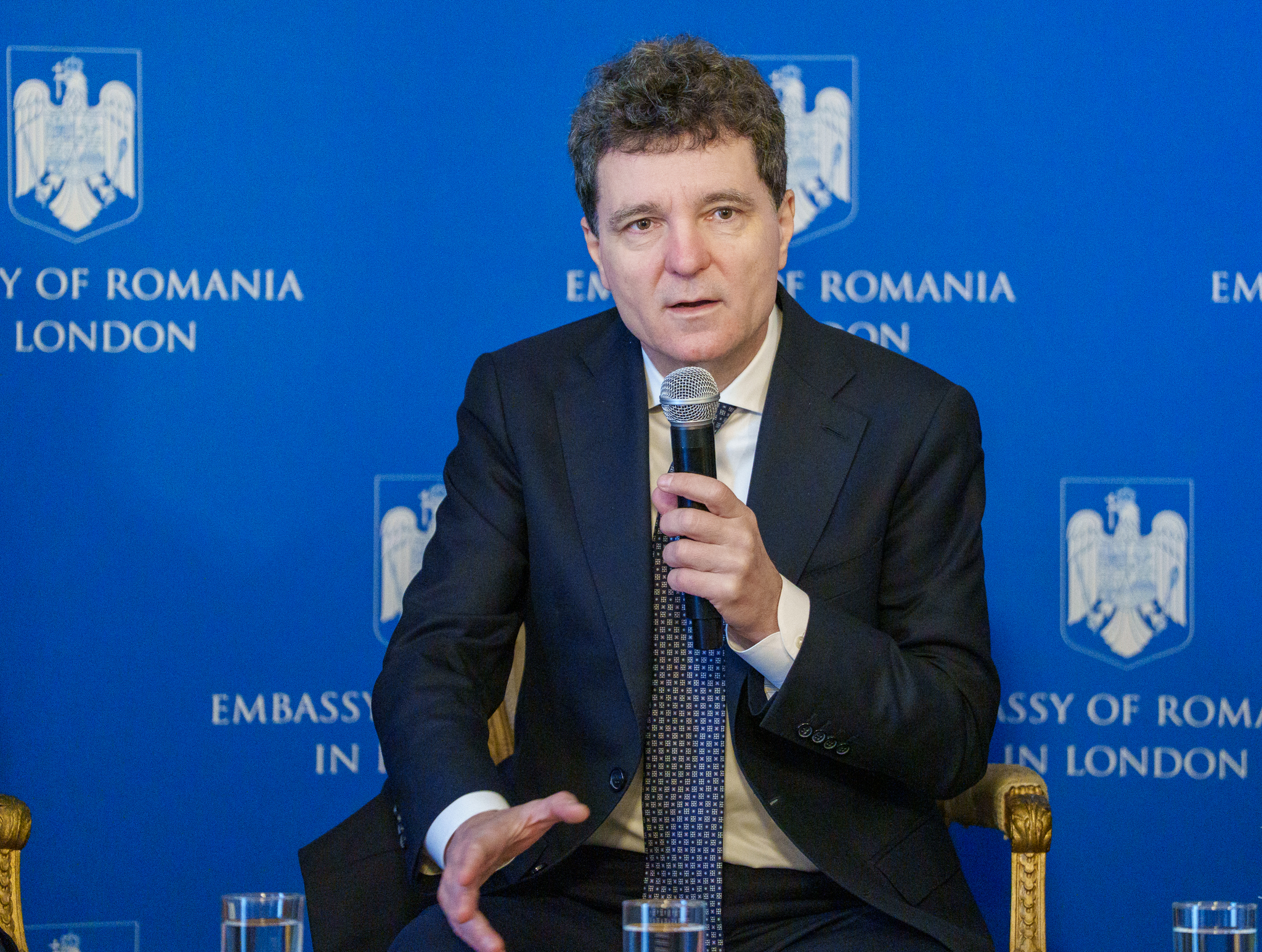 Nicuşor Dan vorbind la o conferință despre sprijin Ucraina și securitate România, cu steagul României în fundal | sursa foto: News.ro Nicuşor Dan vorbind la o conferință despre sprijin Ucraina și securitate România, cu steagul României în fundal | sursa foto: News.ro