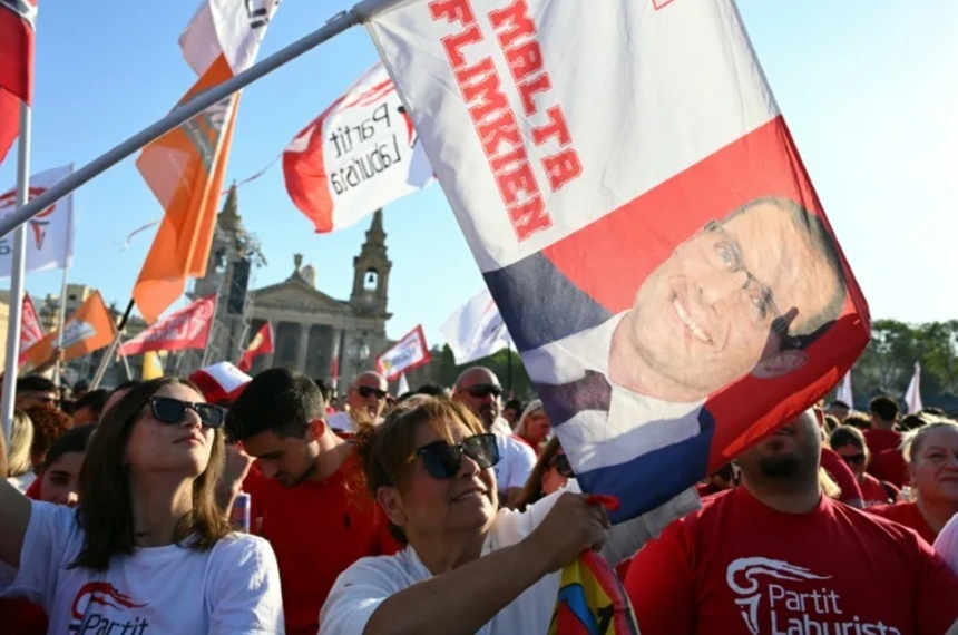 Robert Abela vorbind în fața susținătorilor Partidului Laburist în timpul alegerilor legislative Malta, cu steaguri roșii în mulțime. | sursa foto: News.ro Robert Abela vorbind în fața susținătorilor Partidului Laburist în timpul alegerilor legislative Malta, cu steaguri roșii în mulțime. | sursa foto: News.ro