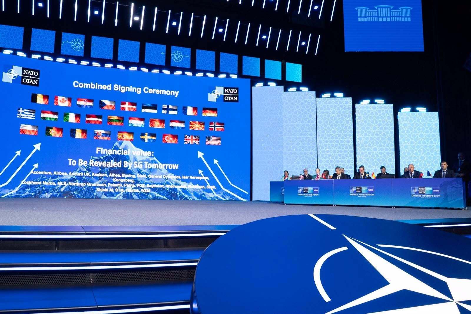 Arme rază lungă expuse în standuri la summit NATO, reprezentanți discutând cooperare NATO și creșterea buget apărare europeană. | sursa foto: News.ro Arme rază lungă expuse în standuri la summit NATO, reprezentanți discutând cooperare NATO și creșterea buget apărare europeană. | sursa foto: News.ro