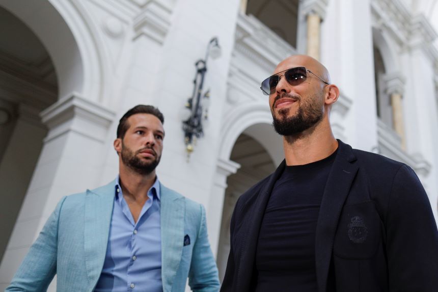 Frații Tate în cătușe, escortați de polițiști în fața instanței din Florida, în contextul extrădării și acuzațiilor trafic persoane. | sursa foto: News.ro Frații Tate în cătușe, escortați de polițiști în fața instanței din Florida, în contextul extrădării și acuzațiilor trafic persoane. | sursa foto: News.ro