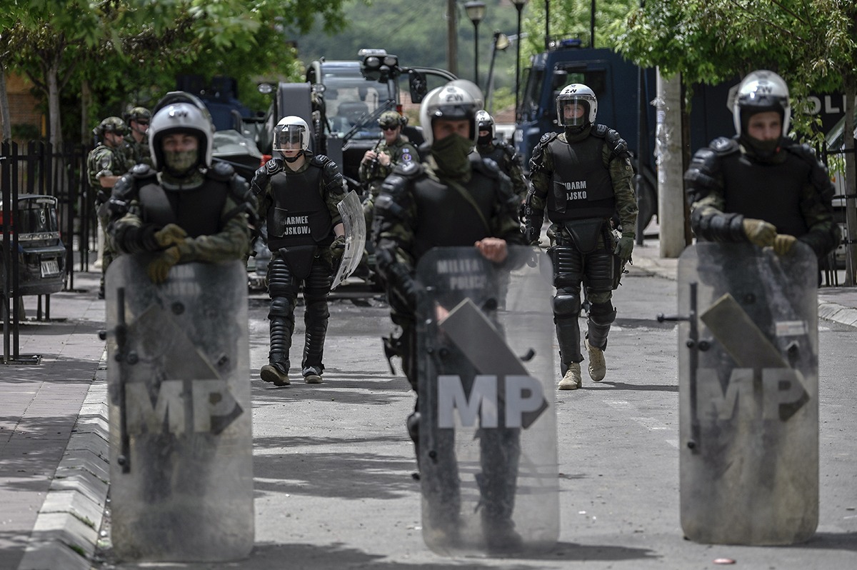 Soldați KFOR ai NATO Kosovo supraveghind Mitrovica pod, cu posturi militare și corturi în zona divizată etnic a orașului. | sursa foto: G4Media Soldați KFOR ai NATO Kosovo supraveghind Mitrovica pod, cu posturi militare și corturi în zona divizată etnic a orașului. | sursa foto: G4Media