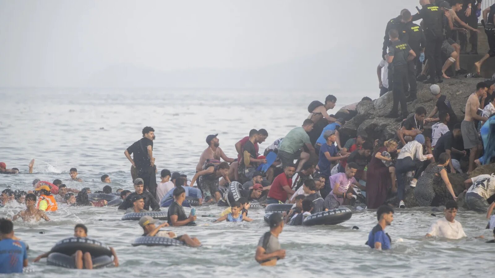 Granița dintre Spania și Maroc cu forțe de ordine spaniole și migranți în contextul crizei migranților Ceuta și cooperării serviciilor secrete | sursa foto: Stiri pe Surse Granița dintre Spania și Maroc cu forțe de ordine spaniole și migranți în contextul crizei migranților Ceuta și cooperării serviciilor secrete | sursa foto: Stiri pe Surse
