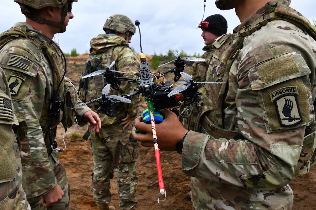 Dronă militară avansată zburând deasupra unui teren de antrenament, ilustrând tehnologie militară și inteligență artificială militară în acțiune. | sursa foto: Adevarul Dronă militară avansată zburând deasupra unui teren de antrenament, ilustrând tehnologie militară și inteligență artificială militară în acțiune. | sursa foto: Adevarul