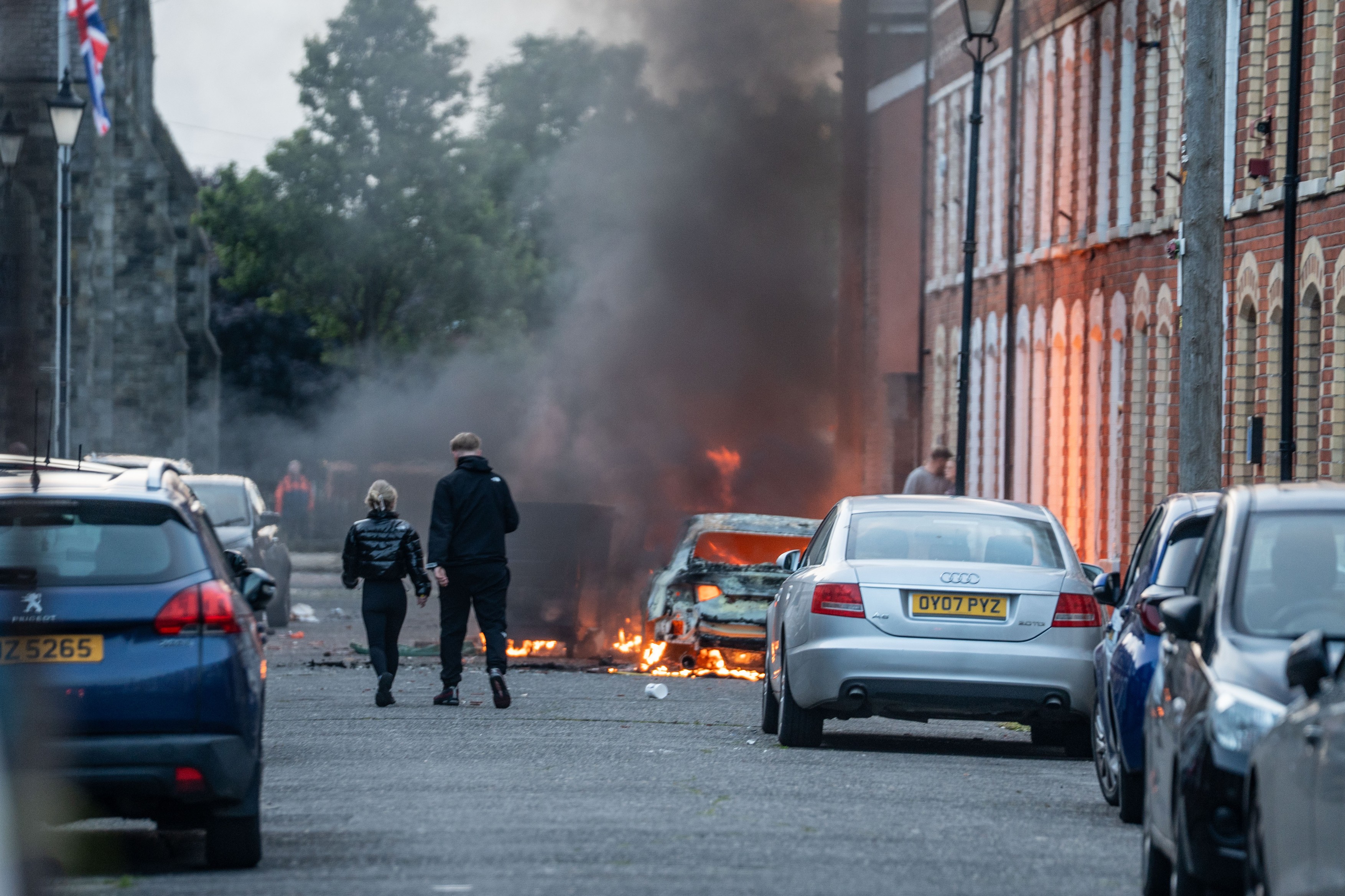 Protestatari mascați incendiază un autobuz Glider pe Newtownards Road în timpul violențelor Belfast declanșate de proteste anti-imigranți și atac cu cuțitul. | sursa foto: HotNews Protestatari mascați incendiază un autobuz Glider pe Newtownards Road în timpul violențelor Belfast declanșate de proteste anti-imigranți și atac cu cuțitul. | sursa foto: HotNews