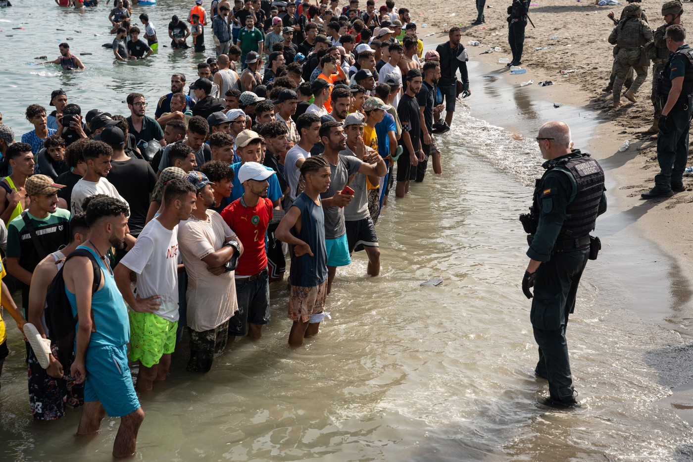 Zeci de migranți traversând granița din Maroc spre Ceuta în timpul crizei Ceuta, migrație ilegală și tensiuni în relațiile Spania Maroc | sursa foto: HotNews Zeci de migranți traversând granița din Maroc spre Ceuta în timpul crizei Ceuta, migrație ilegală și tensiuni în relațiile Spania Maroc | sursa foto: HotNews