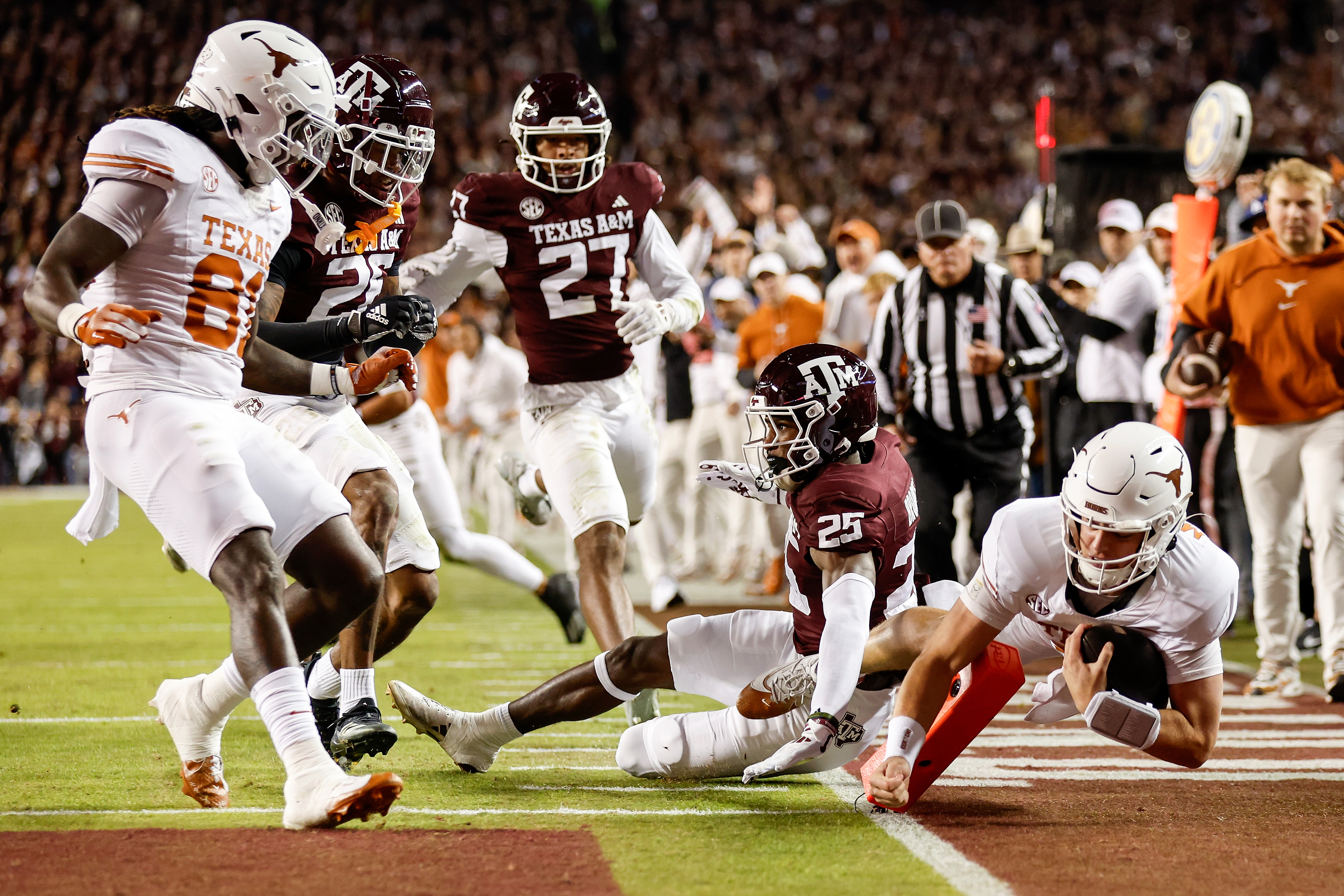 COLLEGE STATION, TEXAS - NOVEMBER 30: Arch Manning #16 of the Texas Longhorns dives into the end zone for a touchdown against Dalton Brooks #25 of the Texas A&M Aggies in the first half against the Texas A&M Aggies at Kyle Field on November 30, 2024 in College Station, Texas. (Photo by Tim Warner/Getty Images)