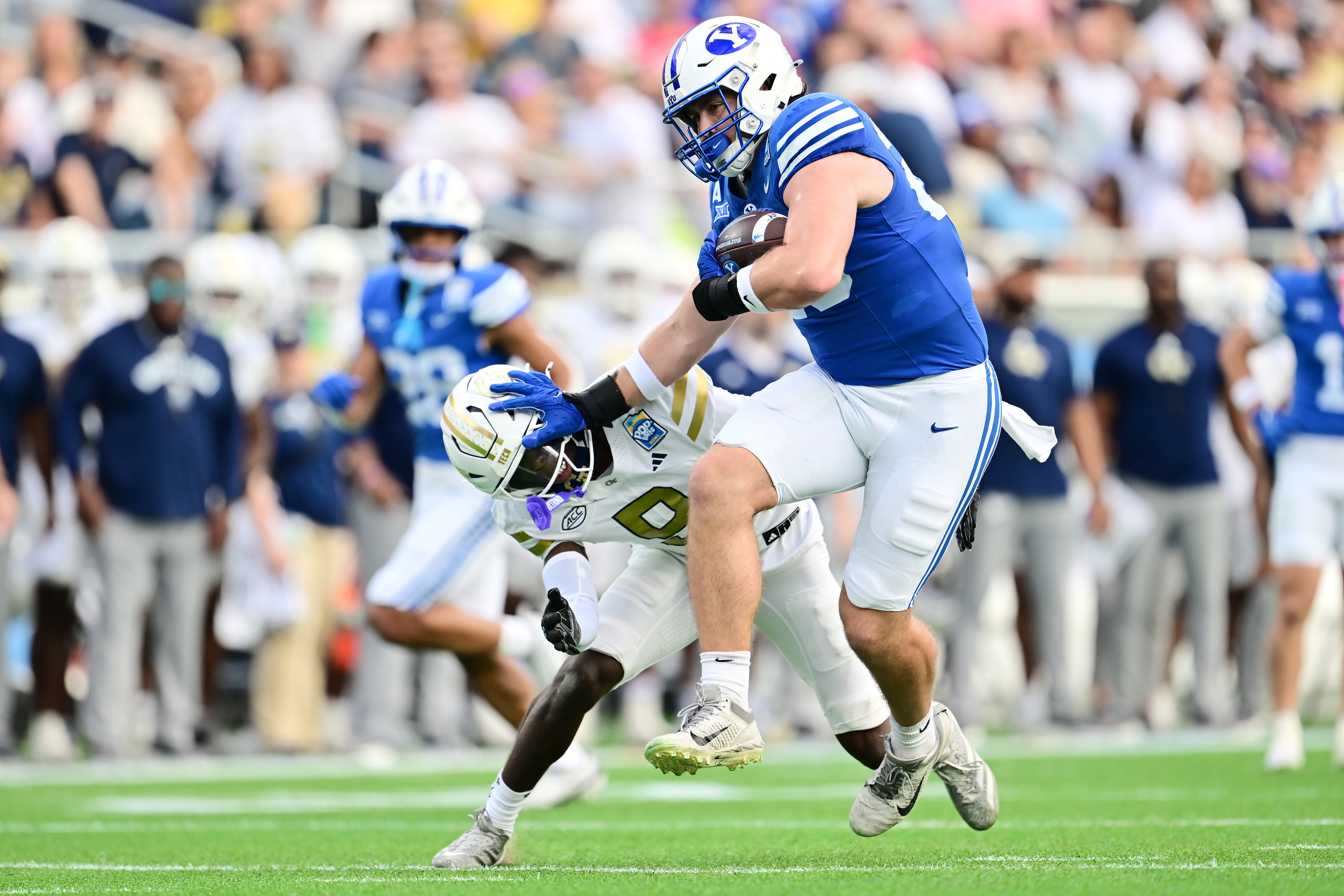 ORLANDO, FLORIDA - DECEMBER 27: Carsen Ryan #20 of the BYU Cougars stiff-arms Omar Daniels #9 of the Georgia Tech Yellow Jackets in the first half during the 2025 Pop-Tarts Bowl at Camping World Stadium on December 27, 2025 in Orlando, Florida. (Photo by Julio Aguilar/Getty Images)
