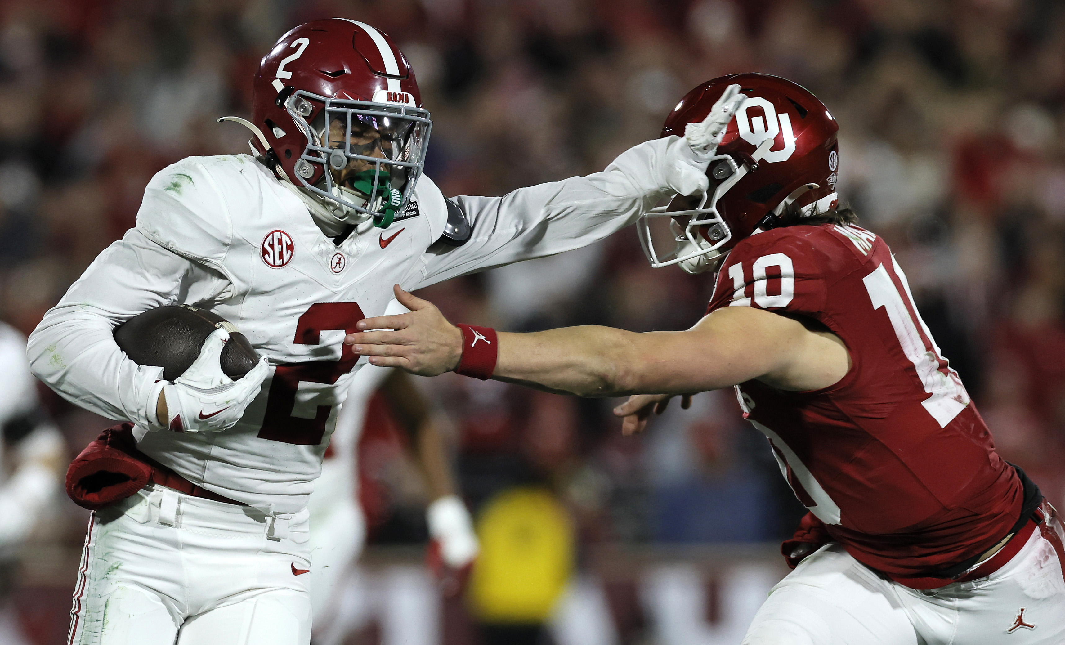 NORMAN, OKLAHOMA - DECEMBER 19: Zabien Brown #2 of the Alabama Crimson Tide stiff arms John Mateer #10 of the Oklahoma Sooners during the second quarter during 2025 College Football Playoff First Round Game at Gaylord Family Oklahoma Memorial Stadium on December 19, 2025 in Norman, Oklahoma. (Photo by Brian Bahr/Getty Images)